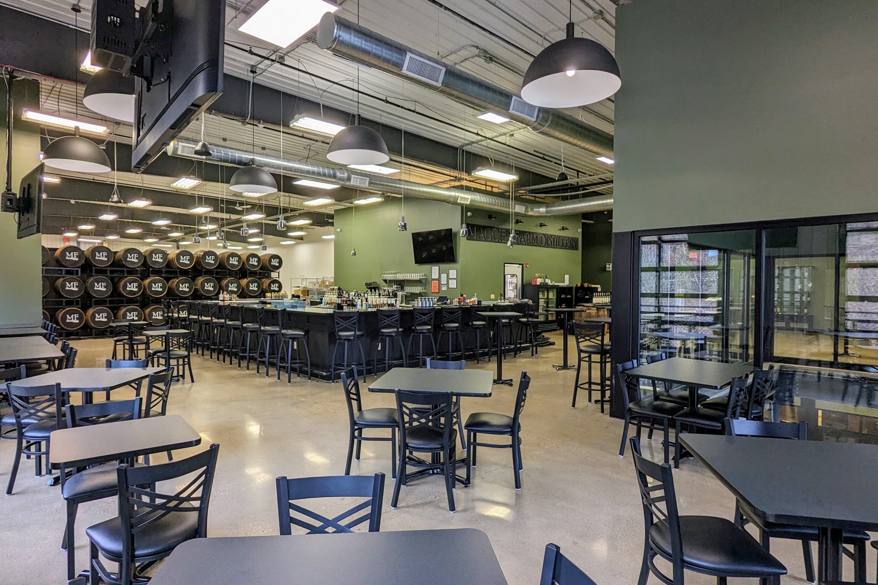 Maggie's Farm Upper St. Clair restaurant with moss green walls, high ceilings, and black tables and chairs.